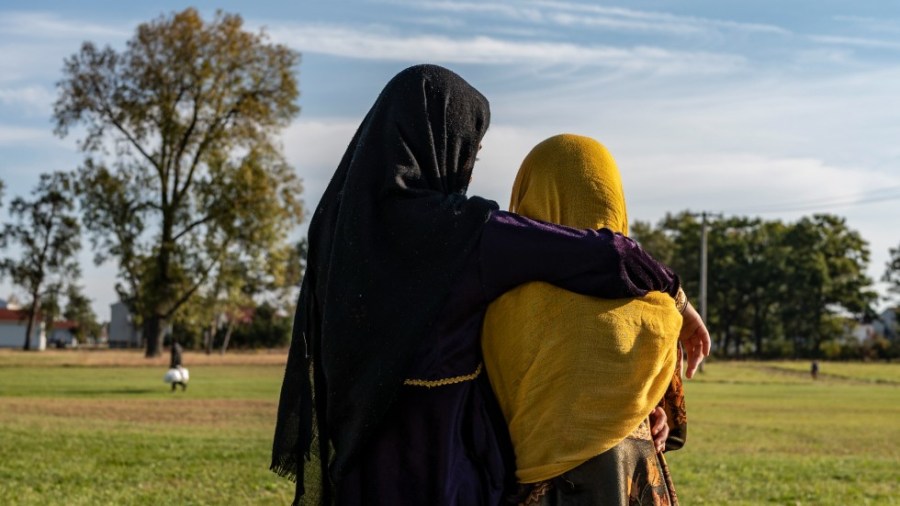 Afghan refugee girls watch a soccer match near where they are staying at the Ft. McCoy Army base in Wisconsin