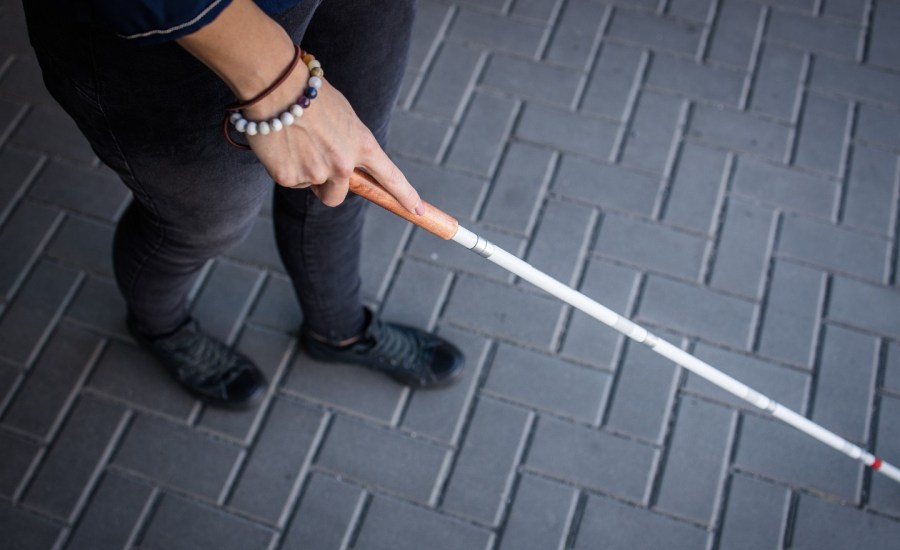 stock photo of lower body of a person holding a walking stick