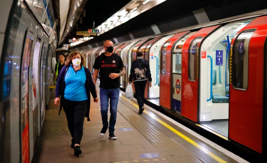 Commuters wear facemasks as they travel on the London Underground