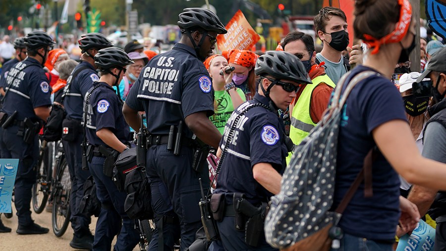 U.S. Capitol Police move protesters staging a sit-in outside the U.S. Capitol on Friday, October 15, 2021. The group ‘People vs Fossil Fuels’ want President Biden to end fossil fuel projects and to declare climate change a national emergency.