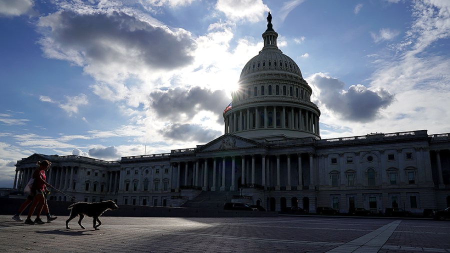 A couple and their dog traverse the East Front Plaza of the U.S. Capitol on Thursday, October 7, 2021.