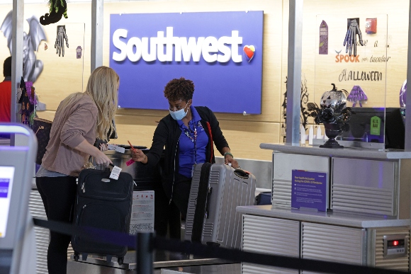 A Southwest Airlines employee helps a passenger to check in