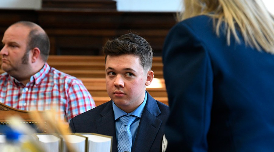 Kyle Rittenhouse sits at a table in court