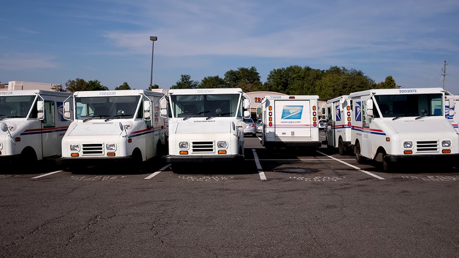 U.S. Postal Service trucks are seen in a parking lot at the Newgate Shopping Center in Centerville, Va., on Thursday, October 14, 2021.