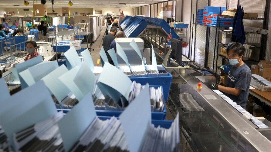 A worker runs mail-in-ballots through a sorting machine at the Santa Clara County in California