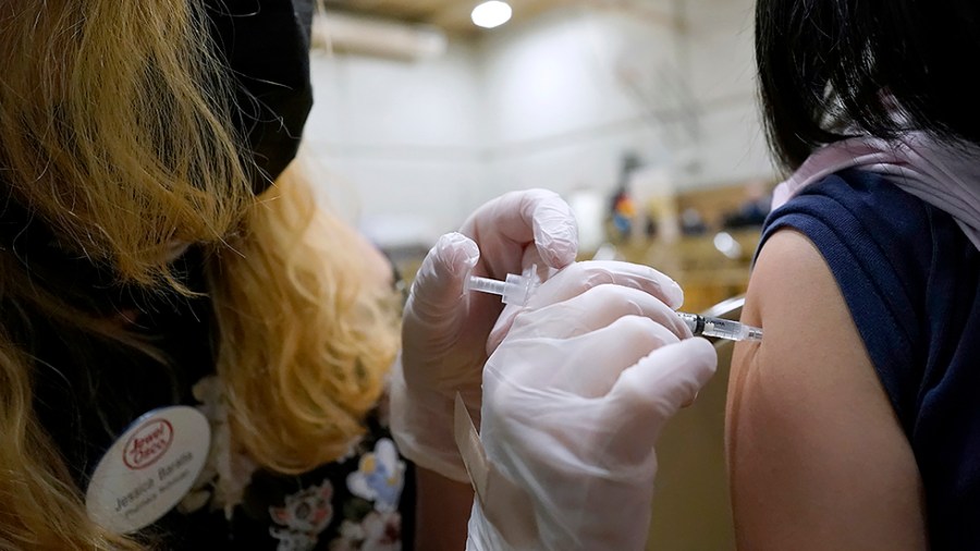 A healthcare worker administrates a dose of the Pfizer COVID-19 vaccine to a student during a vaccination clinic for ages 5 - 11 hosted by Jewel Osco in Wheeling, Ill., on Wednesday, Nov. 17, 2021