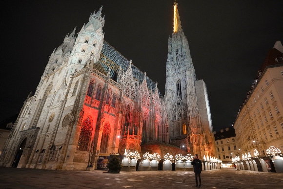 A man takes photographs in a deserted square at the St. Stephen's Cathedral in Vienna, Austria