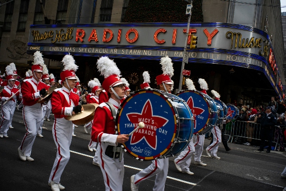 Revelers makes their way down the Avenue of the Americas in front of Radio City Music Hall during the Macy's Thanksgiving Day Parade in New York