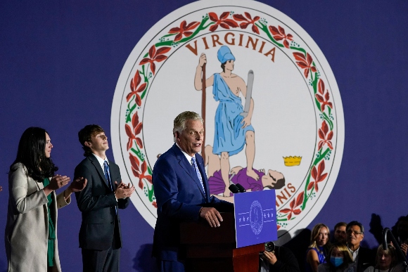 Democratic gubernatorial candidate Terry McAuliffe gestures as he speaks in front of the flag of Virginia