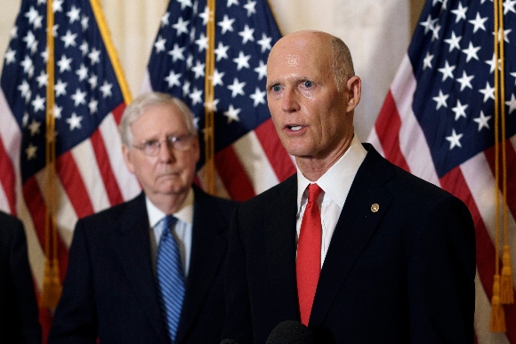 Sen. Rick Scott, R-Fla., joined at left by Senate Majority Leader Mitch McConnell, R-Ky., speaks to reporters