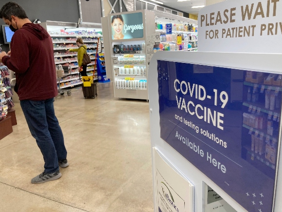 A patient waits to be called for a COVID-19 vaccination booster shot outside a pharmacy in a grocery store