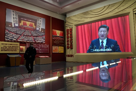 Chinese President Xi Jinping's image on a big screen is reflected on glass at the Museum of the Communist Party of China