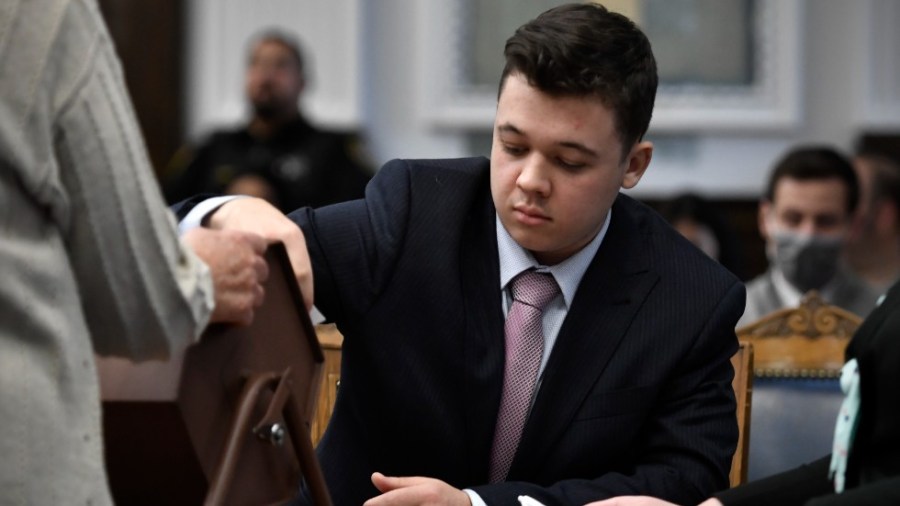 Kyle Rittenhouse pulls numbers of jurors out of a tumbler during his trial at the Kenosha County Courthouse