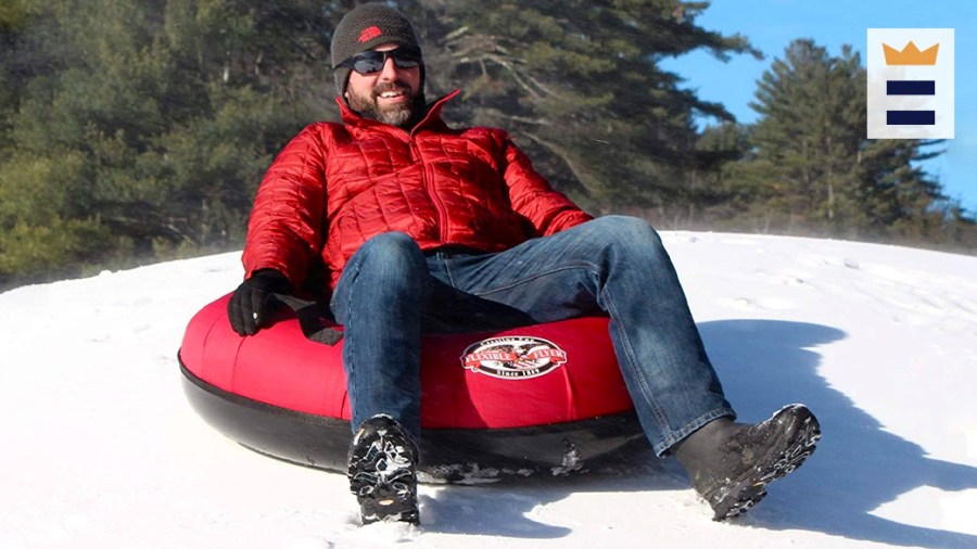 Man dressed in winter gear on a red snow tube