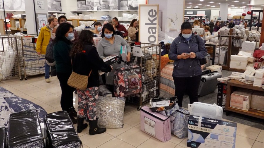 Customers wait in line to checkout during a Black Friday sale at Macy's in Indianapols