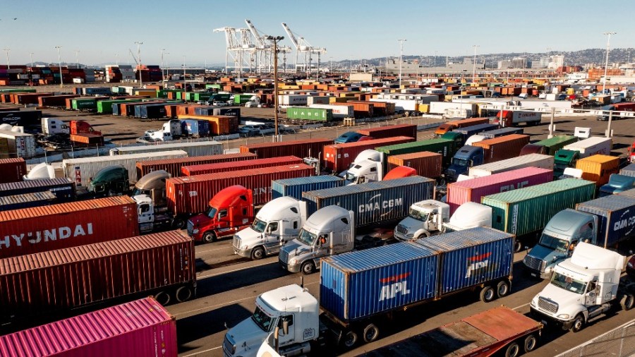 Trucks line up to enter a Port of Oakland shipping terminal in Oakland, Calif.