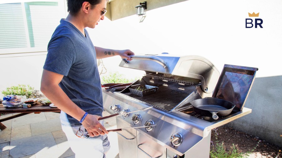 Person cooking on the grill with a cooking basket and cast iron pan