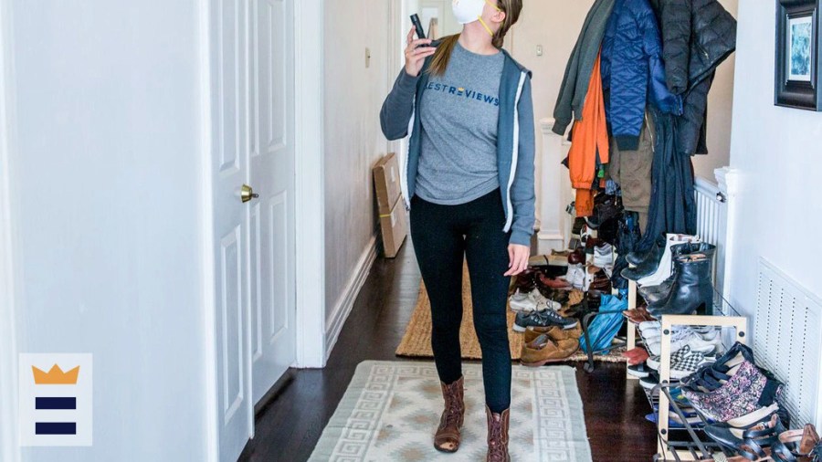 Person wearing leggings standing in a hallway filled with many coats and pairs of shoes