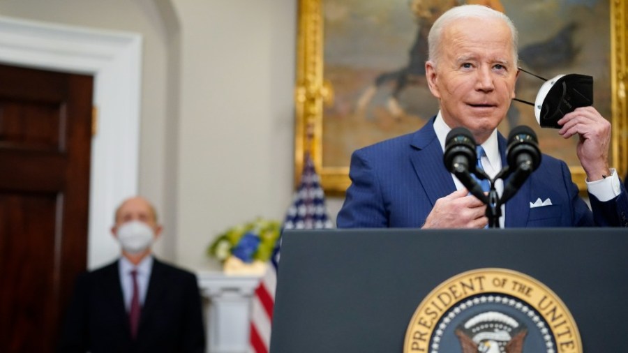 President Joe Biden removes his face mask as he prepares to deliver remarks on the retirement of Supreme Court Associate Justice Stephen Breyer