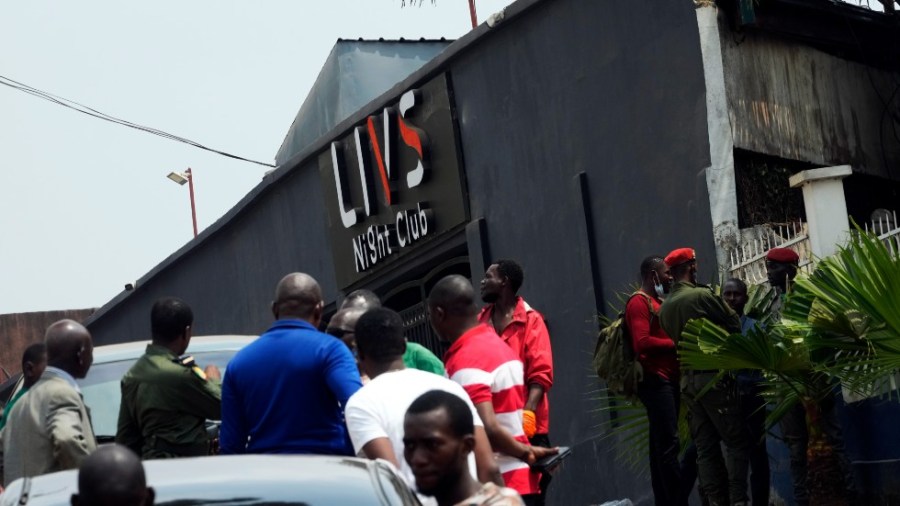 Police officers and officials stand outside the Livs Night Club in Yaounde, Cameroon