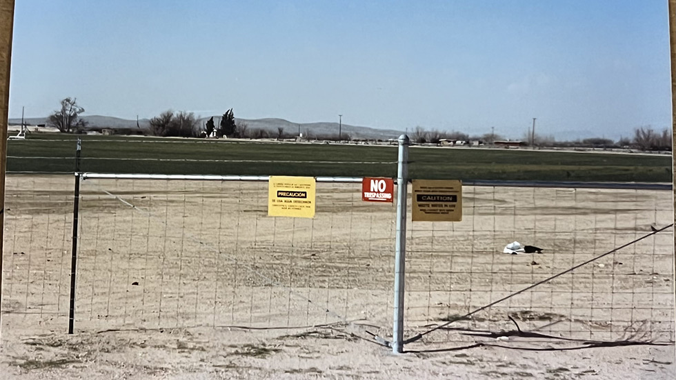 A warning sign is posted on the fence of a PG&E plant in Hinkley, Calif. as seen in a photo from the early to mid 1990s.