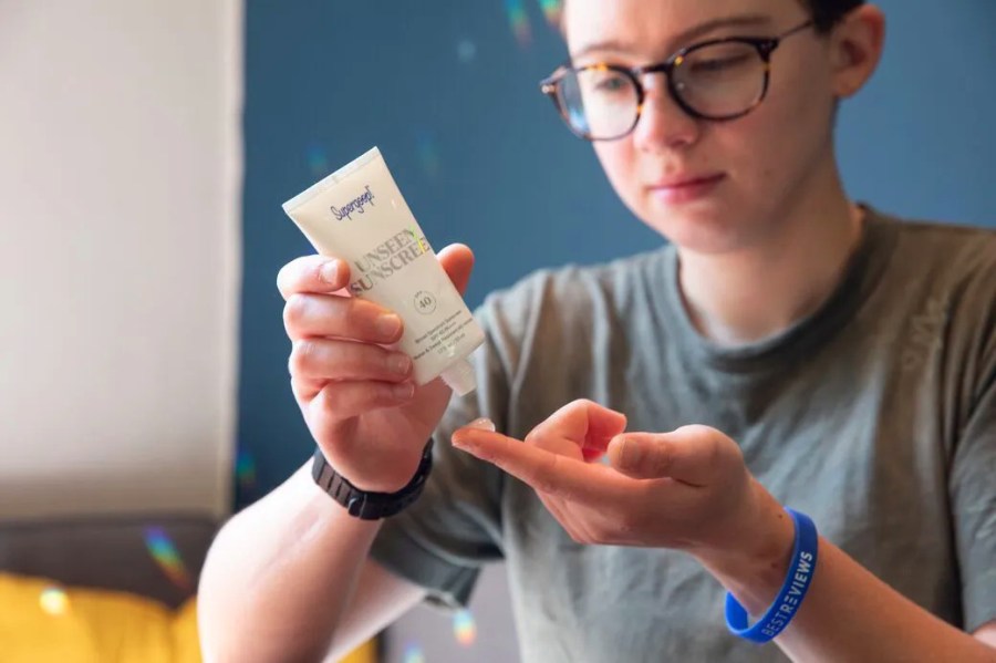 Child placing a small amount of sunscreen on their finger