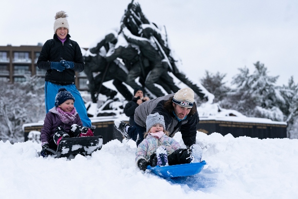 People sled down the hill at the United States Marine Corps War Memorial