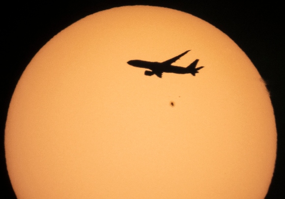 A cargo Boeing 777 of China Southern Airlines flying from Amsterdam to Shanghai is silhouetted against the Sun