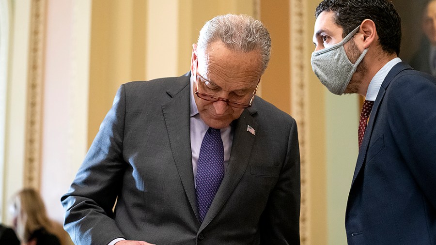 Majority Leader Charles Schumer (D-N.Y.) speaks to communication director Justin Goodman as Senate Democrats address reporters after the weekly policy luncheon on Tuesday, November 30, 2021.