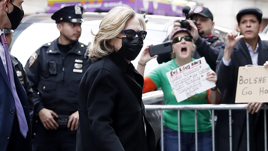 Former Democratic presidential candidate Hillary Clinton walks by a group of protesters when she arrives at the New York State Democratic Committee 2022 State Nominating Convention in New York City on Thursday, February 17, 2022.