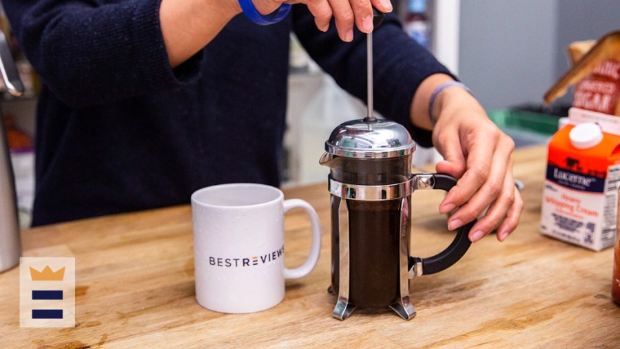 Person using a French press coffee maker in their kitchen