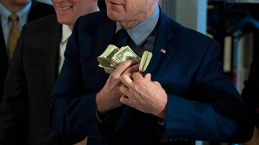 Sen. Todd Young (R-Ind.) jokingly pockets money used by Sen. Roger Marshall (R-Kan.) as a visual aid during a press conference on Wednesday, February 16, 2022 to discuss inflation during President Biden’s administration.