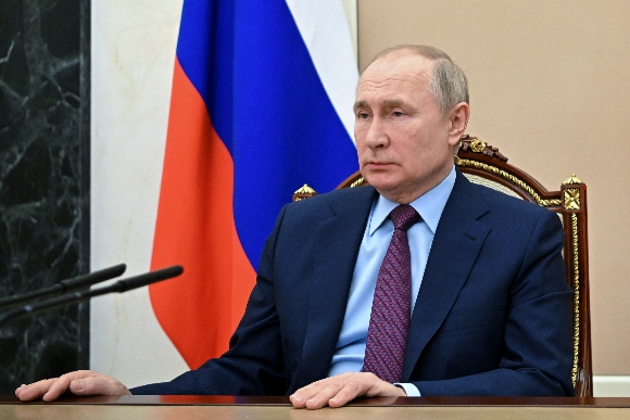 Russian President Vladimir Putin listens to Russian Russian Defense Minister Sergei Shoigu during their meeting