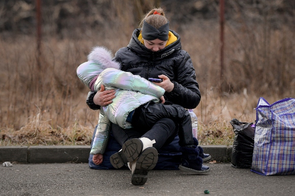 Refugees that fled the conflict from neighboring Ukraine await transportation at the Romanian-Ukrainian border