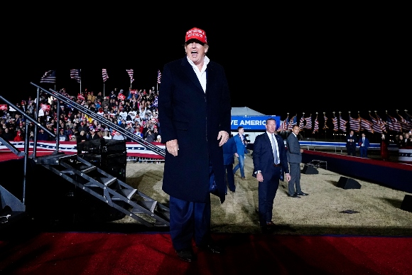 Former President Donald Trump smiles at the crowd after speaking at a rally