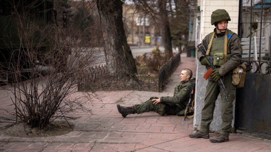 A Ukrainian soldier sits injured in cross fire inside the city of Kyiv, Ukraine