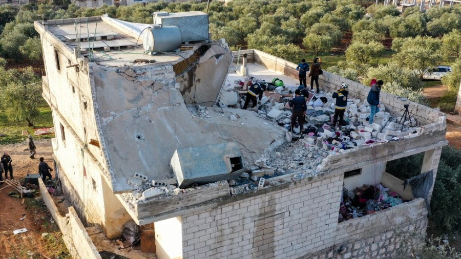 People inspect a destroyed house following an operation by the U.S. military in the Syrian village of Atmeh