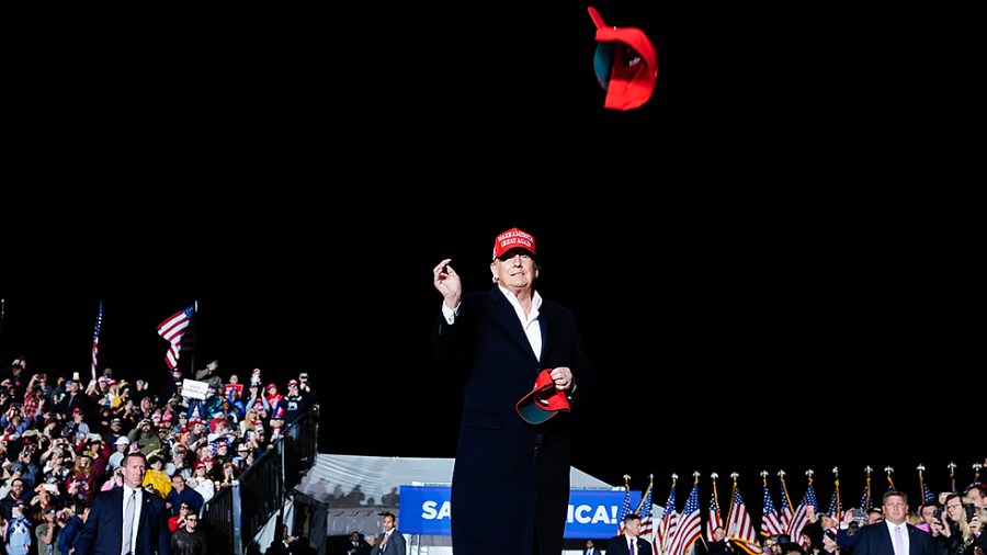 Former President Donald Trump tosses a hat to the crowd as he arrives to speak at a Save America Rally Saturday, Jan. 15, 2022, in Florence, Ariz.