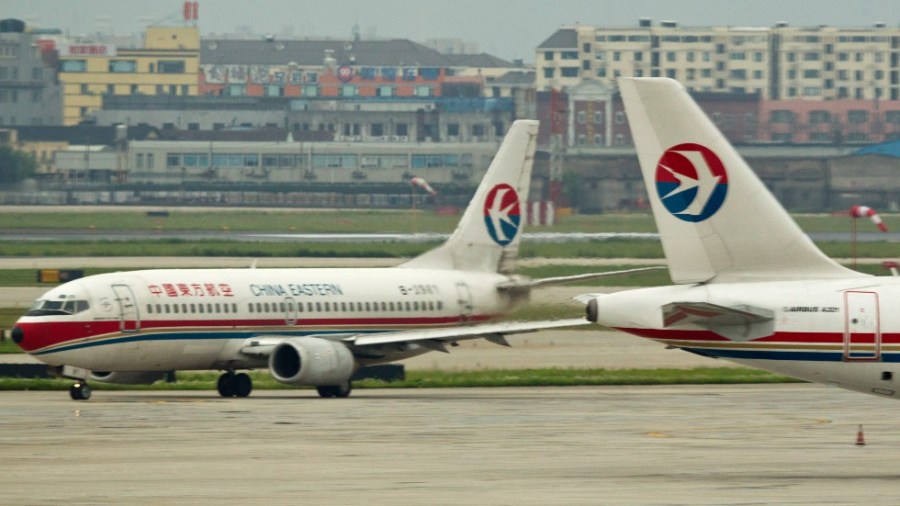 A China Eastern airline jet is partially blurred by the heated air emitted from another jet at Hongqiao Airport in Shanghai, China