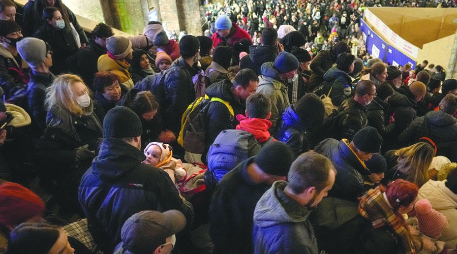 People crowd stairs in a train station.