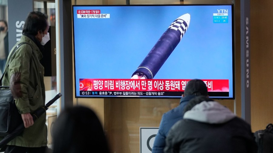 People watch a TV screen showing a news program reporting about North Korea's ICBM at a train station in Seoul, South Korea