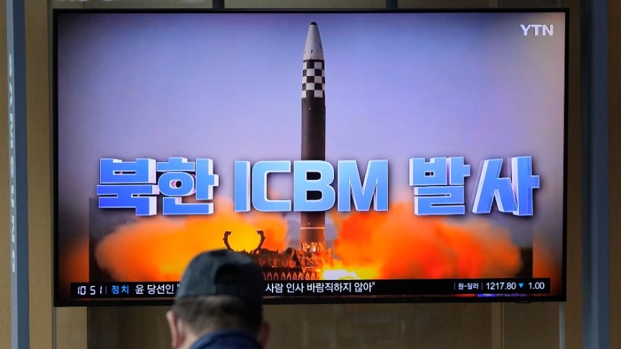 A man watches a TV screen showing a news program reporting about North Korea's ICBM at a train station in Seoul, South Korea, Friday, March 25, 2022