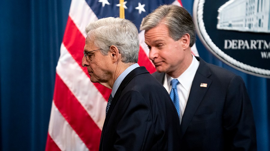 Attorney General Merrick Garland and FBI Director Christopher Wray leave a press conference on Wednesday, April 6, 2022 at the Department of Justice in Washington, D.C., to announce enforcement actions over criminal Russian activity involving crypto currency.