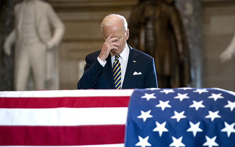 President Biden, center, makes the sign of the cross over Don Young's casket