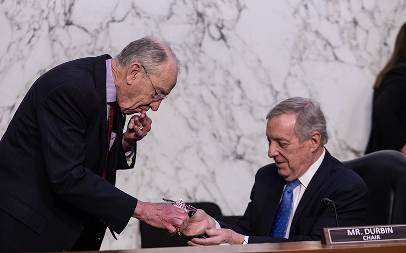 Richard Durbin, left, Chuck Grassley, right share a bag of Beer Nuts