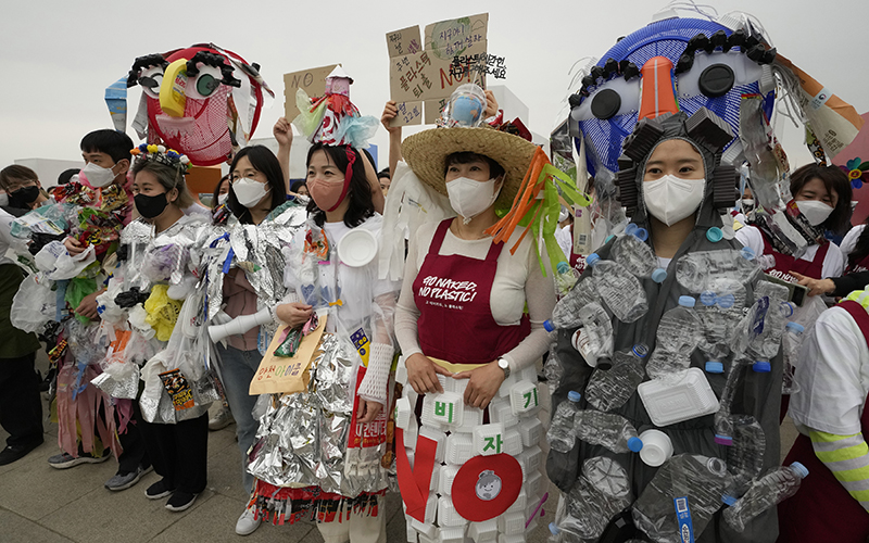 Environmental activists wearing outfits made from plastic waste