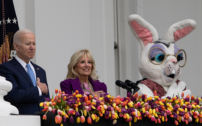 President Biden, Jill Biden and the Easter Bunny are seen at a podium with a decorative flowerbox