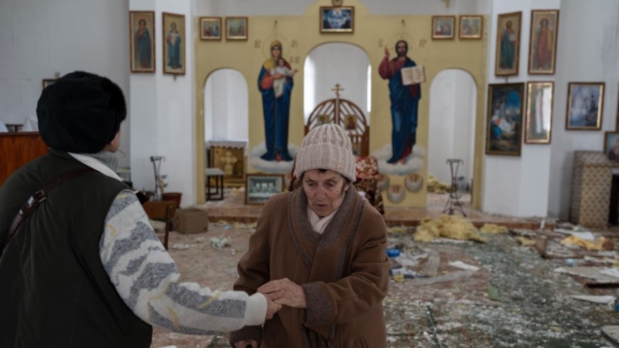 A woman reacts as she enters a damaged church following a Russian attack in the previous weeks in the town of Makarov