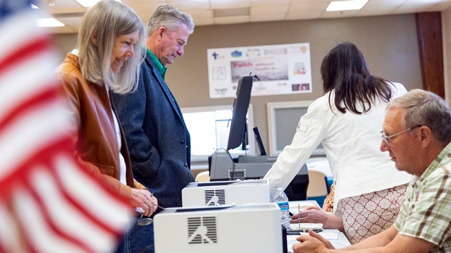 A man and woman check in at a polling place