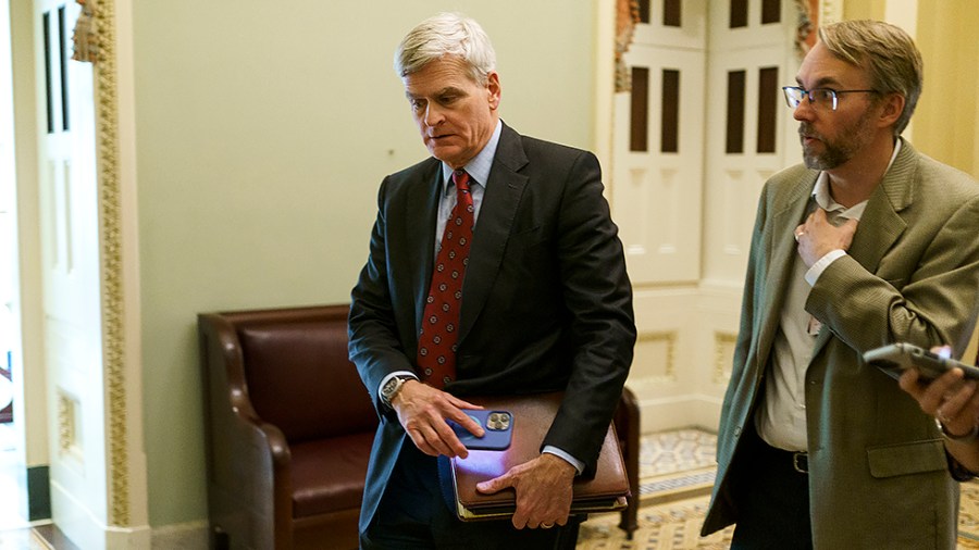 Sen. Bill Cassidy (R-La.) speaks to a reporter as he leaves a Senate Republican Conference luncheon on Wednesday, May 11, 2022.